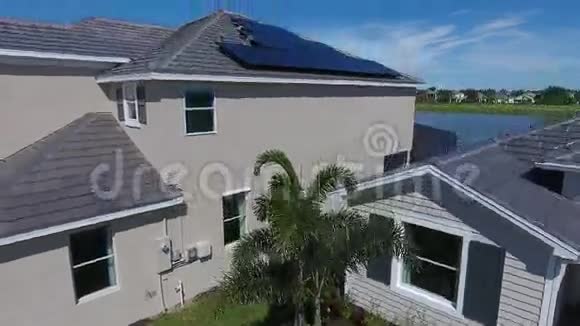 屋顶上有太阳能电池板的郊区房屋带湖的小生态村4k空中拍摄视频的预览图