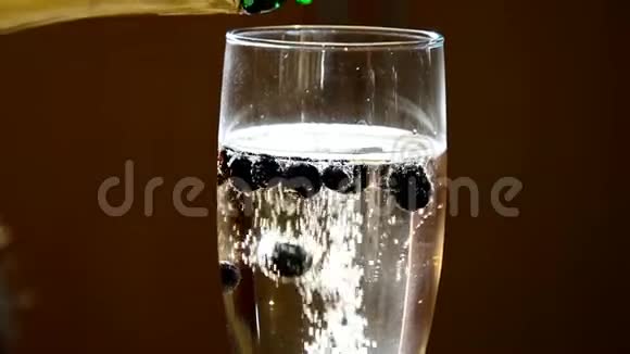 香槟与冷冻蓝莓创造了良好的气泡效果后添加更多的瓶子视频的预览图
