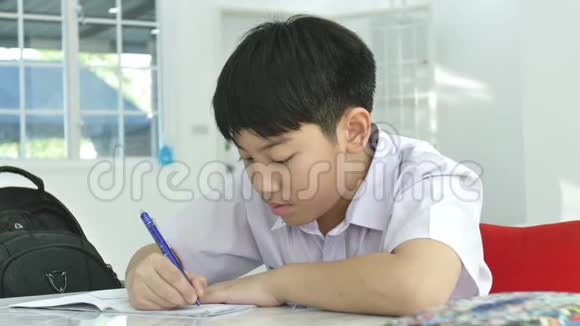 亚洲儿童在白桌上做作业的慢动作视频的预览图