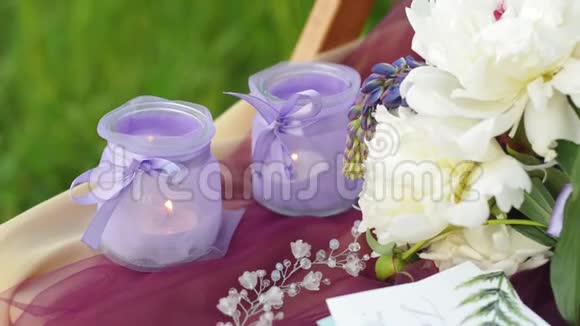 紫色婚礼装饰仪式有燃烧蜡烛的烛台婚礼花环和羽扇豆花束视频的预览图