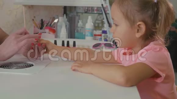 美容师在美容院为小女孩修指甲视频的预览图