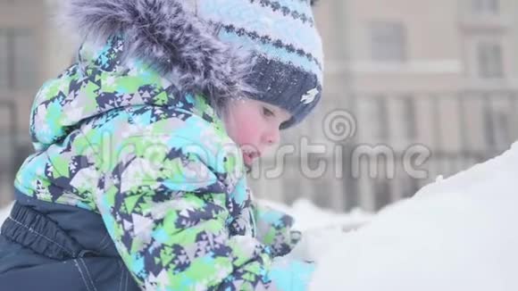 一个小孩子在雪山上玩耍晴朗的霜天新鲜空气中的乐趣和游戏视频的预览图