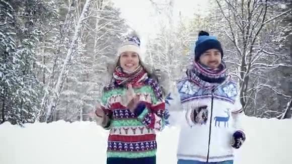 年轻漂亮的一对夫妇在冬天的森林里一起慢跑视频的预览图