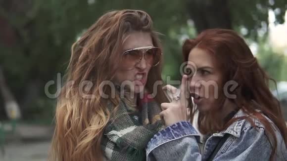 两个红头发女孩的特写肖像女朋友到处闲逛玩得开心慢动作视频的预览图