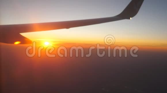 从飞机窗口到美丽的日出或日落天空中的飞机和云翼旅行概念关门视频的预览图