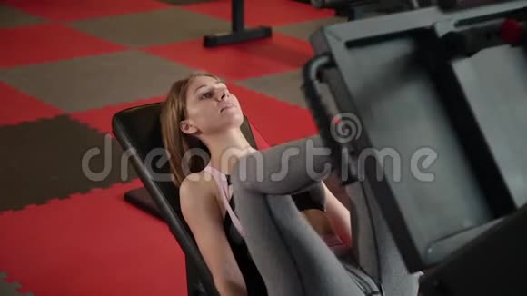 那个女孩在健身房做压腿机视频的预览图