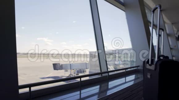 通过机场候机楼窗口登机门和空跑道观看视频的预览图
