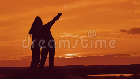 一对剪影在户外自拍最好的朋友的男人和女孩在日落时自拍现代概念视频的预览图