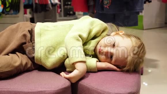 那个疲惫的女孩躺在服装店的小沙发上视频的预览图