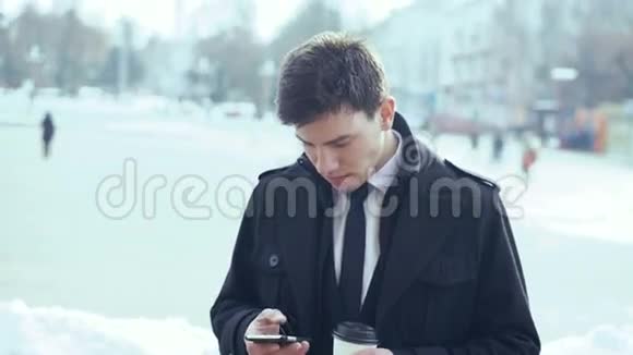 年轻的商人在户外喝咖啡写短信4k视频的预览图