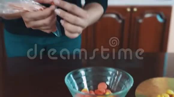 女糖果师在厨房把奶油放在黄色的小通心粉上视频的预览图