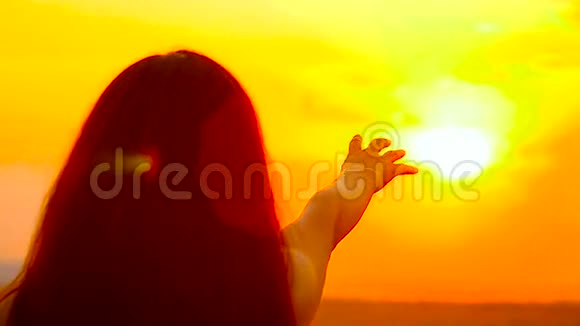 女孩拉着一只手对着金色的太阳视频的预览图
