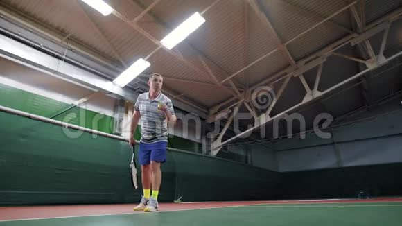 男网球运动员发球运动休闲与实践室内法院视频的预览图