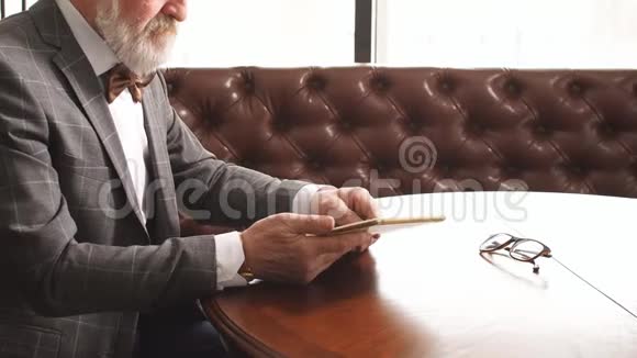 英俊的老人在家庭办公室做数字平板电脑视频的预览图
