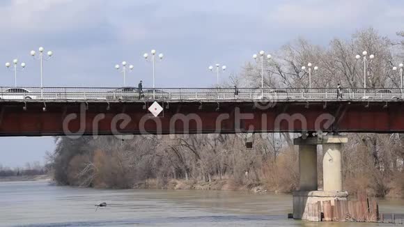 汽车桥在河上在桥上汽车开着人们走着视频的预览图