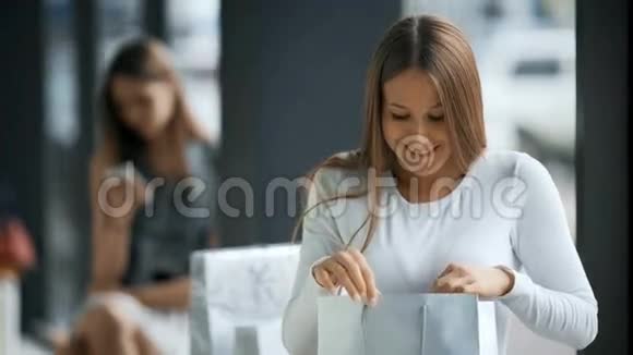 在超市里拿着购物袋的漂亮年轻微笑的女人视频的预览图