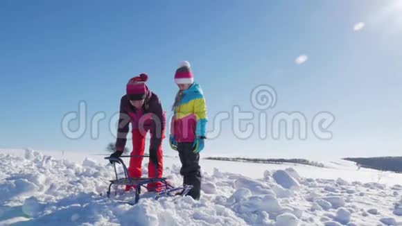 幸福的家庭母亲和孩子女儿在户外散步雪橇妈妈和孩子们的美丽家庭视频的预览图