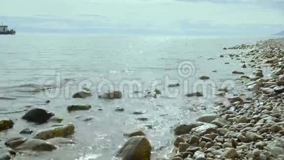 一艘小拖船在离海岸不远的贝加尔湖快速漂浮视频的预览图