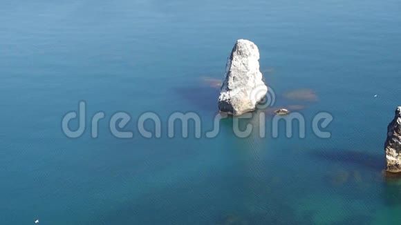 从悬崖俯瞰平静的蓝色海洋中的岩石美景视频的预览图