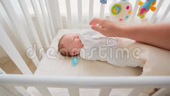 父母手抚婴儿躺在床上给孩子做的特写镜头视频的预览图