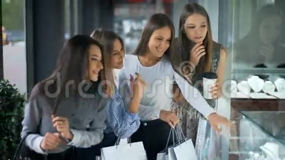 四个快乐的美丽女人在购物看商店视频的预览图
