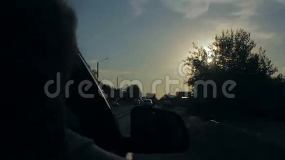 风吹过女孩的头发在一辆有家人的车里日落视频的预览图