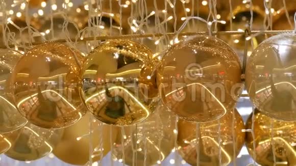 圣诞花环的灯光和金色的球背景模糊新年和圣诞装饰视频的预览图