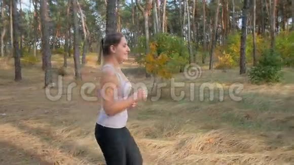 清晨在森林中奔跑的美丽微笑女子慢镜头视频的预览图