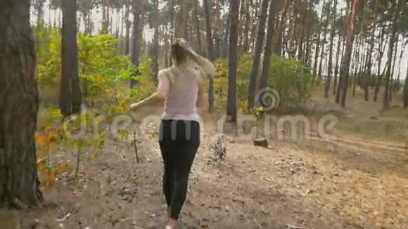 在森林里快速奔跑的年轻女子的后景慢镜头视频的预览图