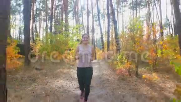 阳光明媚的4天美丽微笑的女人在森林里奔跑视频的预览图