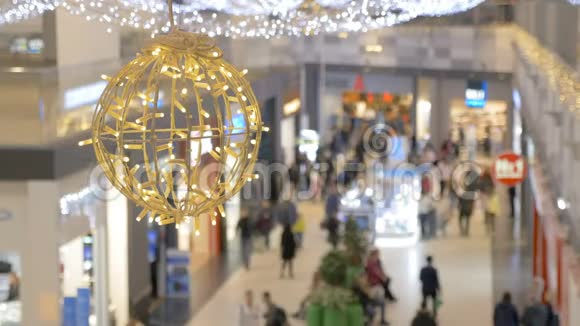 人们穿过购物中心新年庆典节日装饰品大球彩色花环视频的预览图