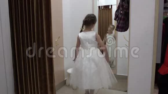 5岁的女孩在服装店试穿一件白色连衣裙视频的预览图