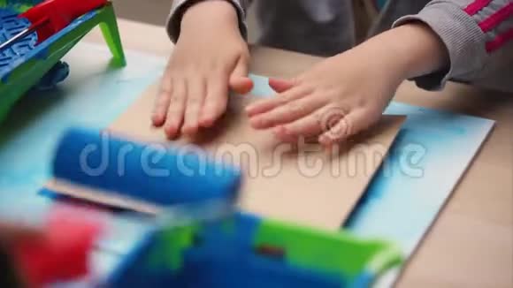 孩子们用纸板上的橡胶邮票画蓝色的猫视频的预览图