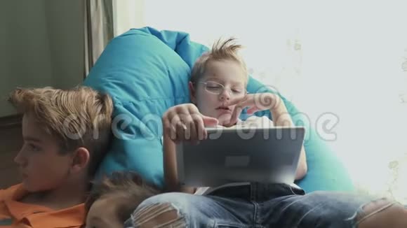 兄弟俩在家里用电子设备视频的预览图