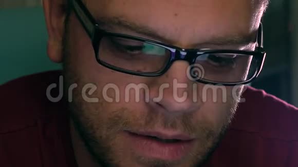 严肃英俊的年轻人戴着黑色眼镜用他的平板电脑说话玻璃屏幕反射视频的预览图