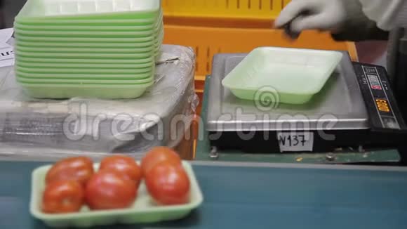 工人用塑料绿色托盘包装西红柿她的工作场所特写视频的预览图