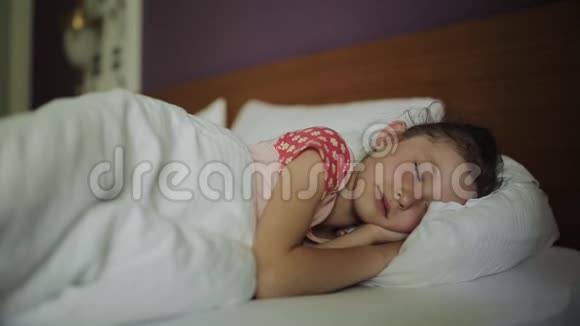 醒来的女人在床上笑着妈妈来到熟睡的孩子身边视频的预览图