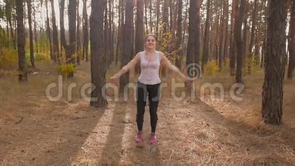 在森林里慢跑之前一个美丽的微笑的女人慢慢地拍下来视频的预览图
