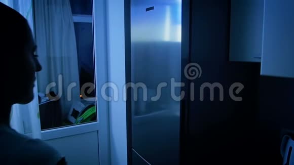 夜间在冰箱内观看饮食的年轻女性慢动作视频视频的预览图