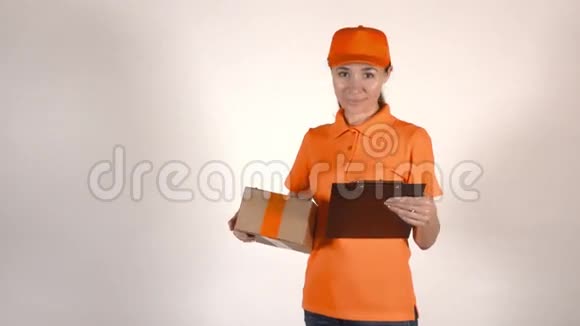 穿着橙色制服的女快递员拿着一个纸板箱4K工作室拍摄的照片视频的预览图
