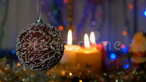 一个大红球新年和圣诞装饰品燃烧蜡烛闪耀的加兰背景模糊视频的预览图