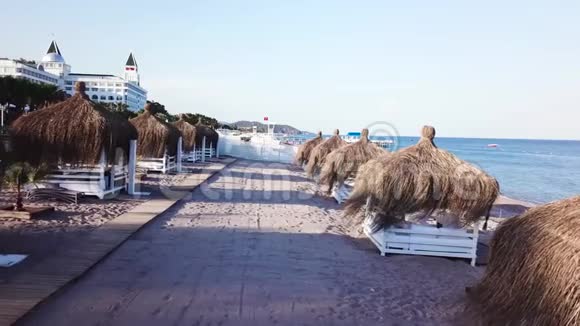 鸟瞰海浪沙滩上有芦苇伞录像带天然伞形花序的沙滩顶景视频的预览图