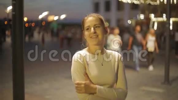 在晚上拥挤的集市上一位优雅的年轻女子的画像视频的预览图