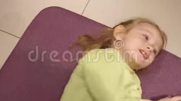 小女孩躺在服装店的一张垫凳上视频的预览图