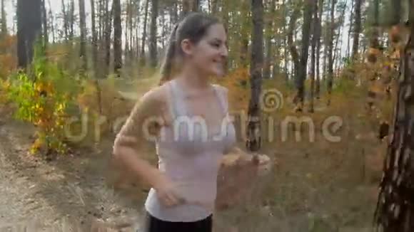 年轻女子在秋天公园跑步的慢镜头视频的预览图