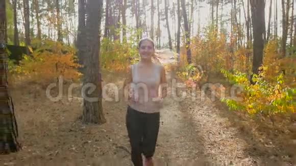 秋季森林中马尾运动的年轻活跃女性慢动作特写镜头视频的预览图