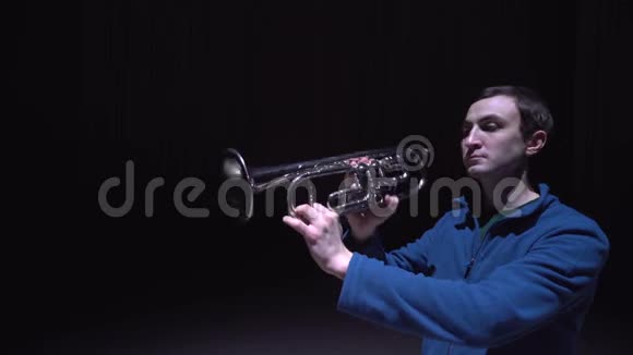 一个音乐家吹喇叭一个孤立的黑色背景视频的预览图
