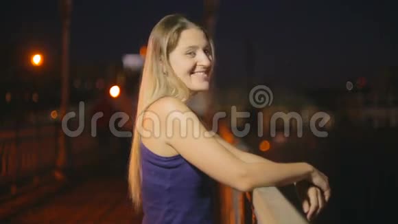 夜晚站在桥上美丽微笑的女人的画像视频的预览图