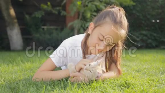 小猫躺在后院地上的可爱女孩画像视频的预览图