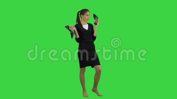 年轻的爱聊天的女人穿着一只鞋就像绿色屏幕上的电话Chroma键视频的预览图